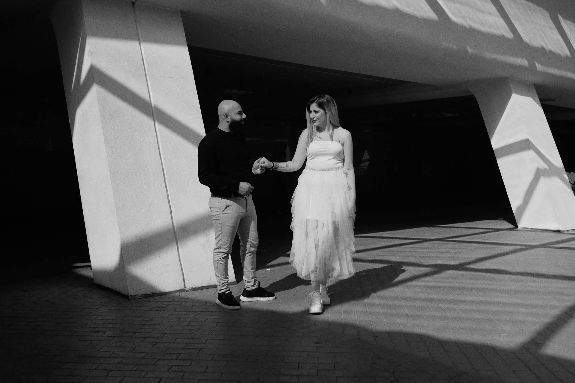 A couple walking through geometric light before their ceremony