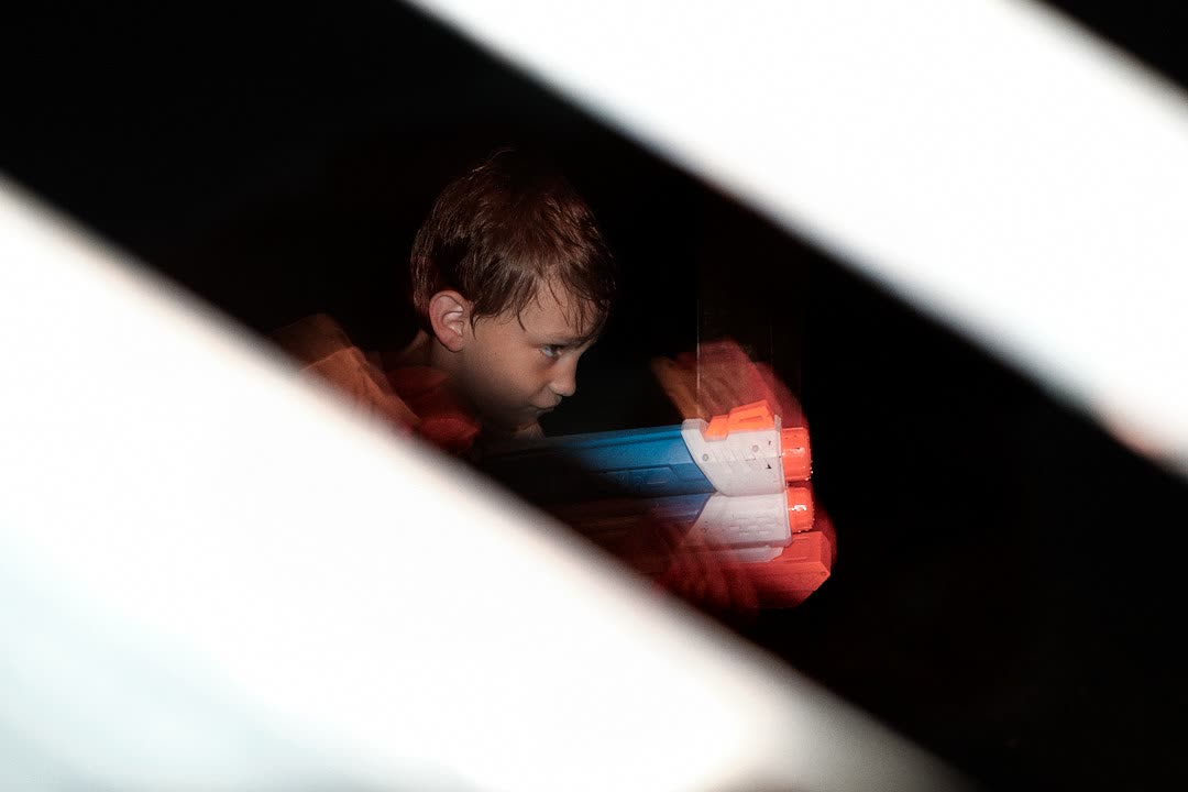 A child framed between streaks of light while holding a colorful toy