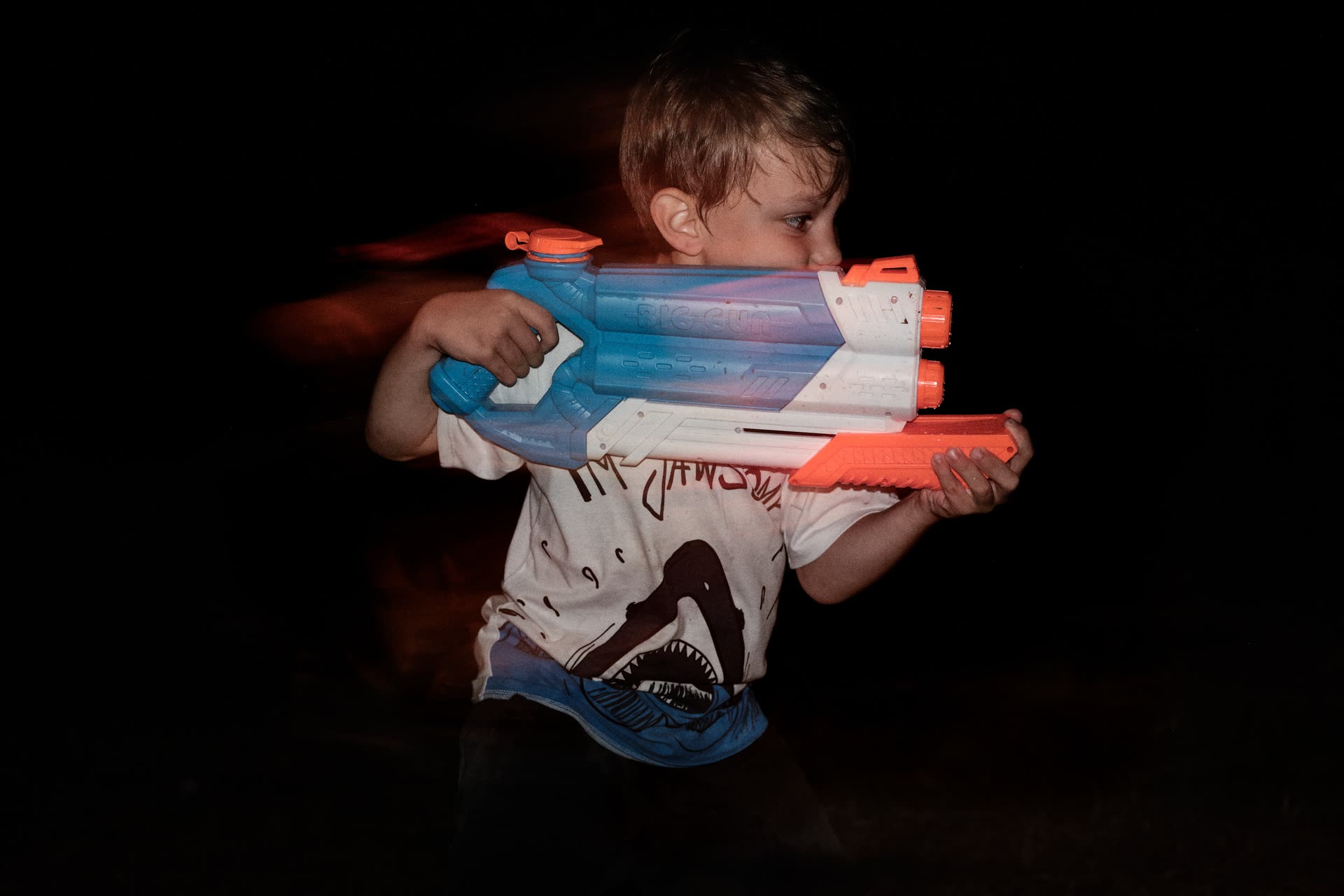 A child holding a colorful toy against the night