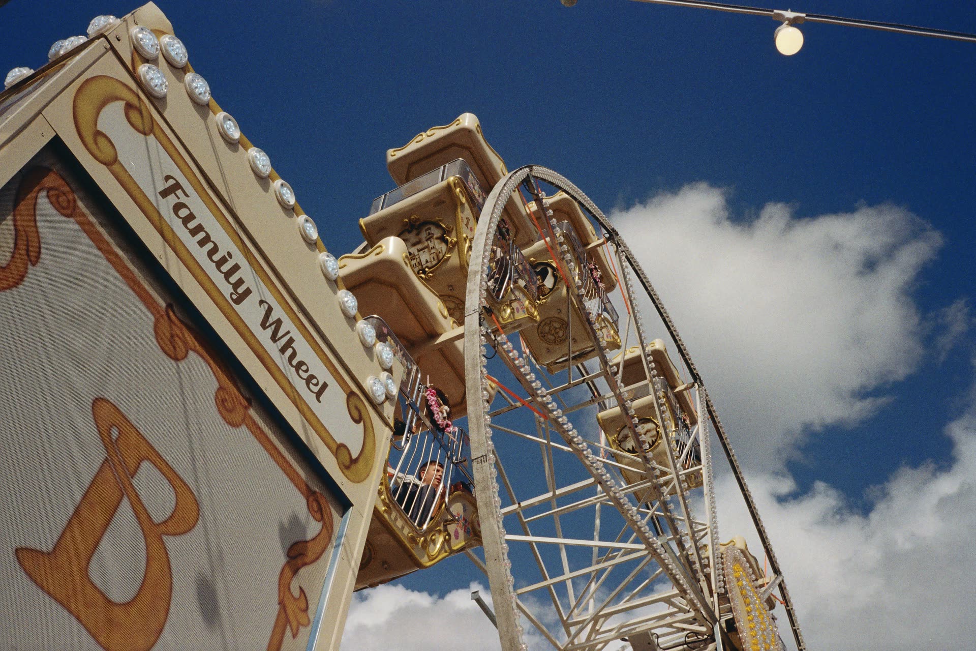 A fairground wheel rising into a deep blue sky